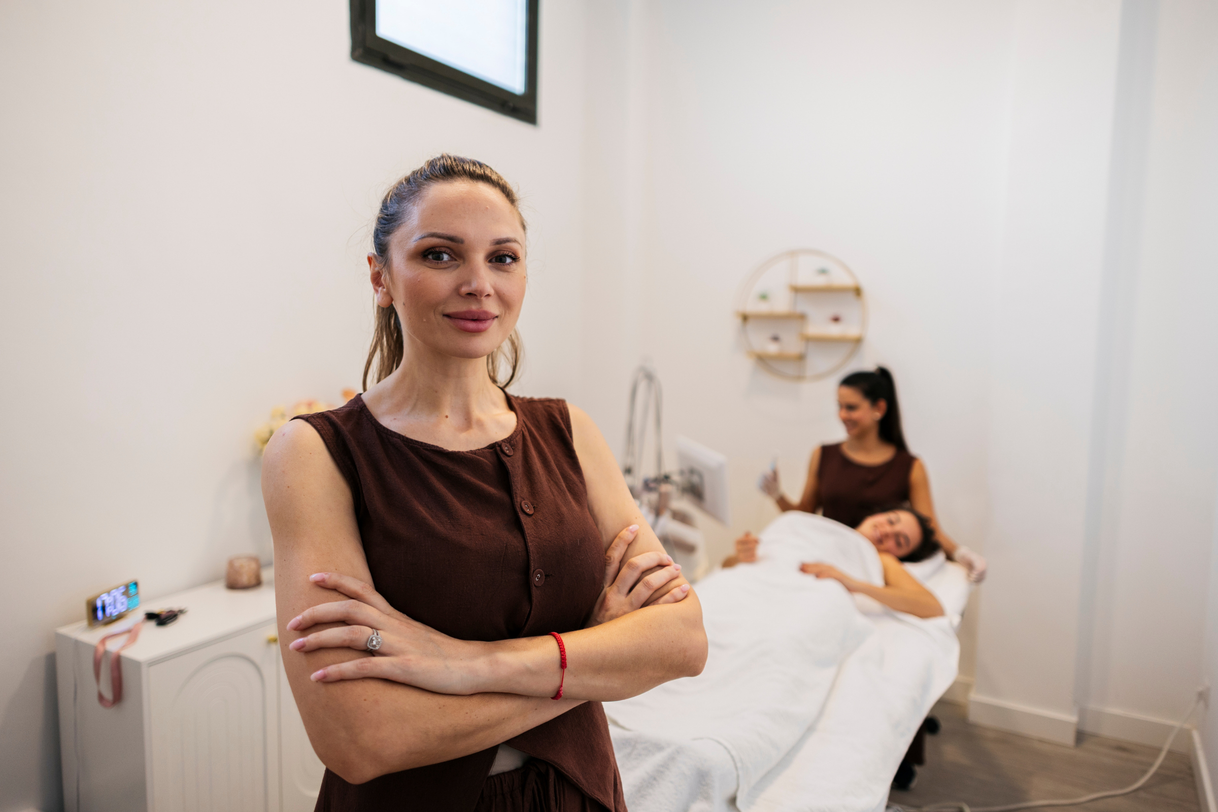 Clinic owner standing confidently in her treatment room